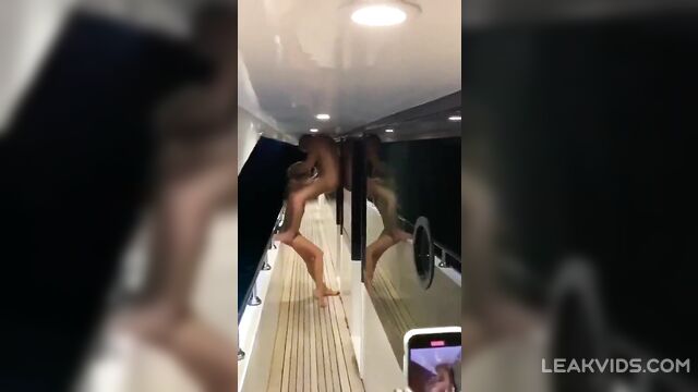 Young prostitute with a beautiful body gives a public blowjob to a rich man at a party on a yacht